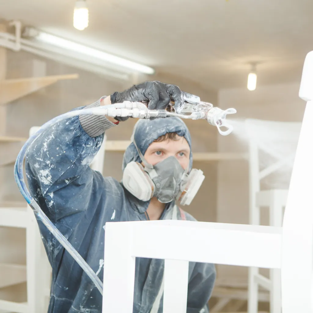 Peintre façadier équipé d’un pulvérisateur airless